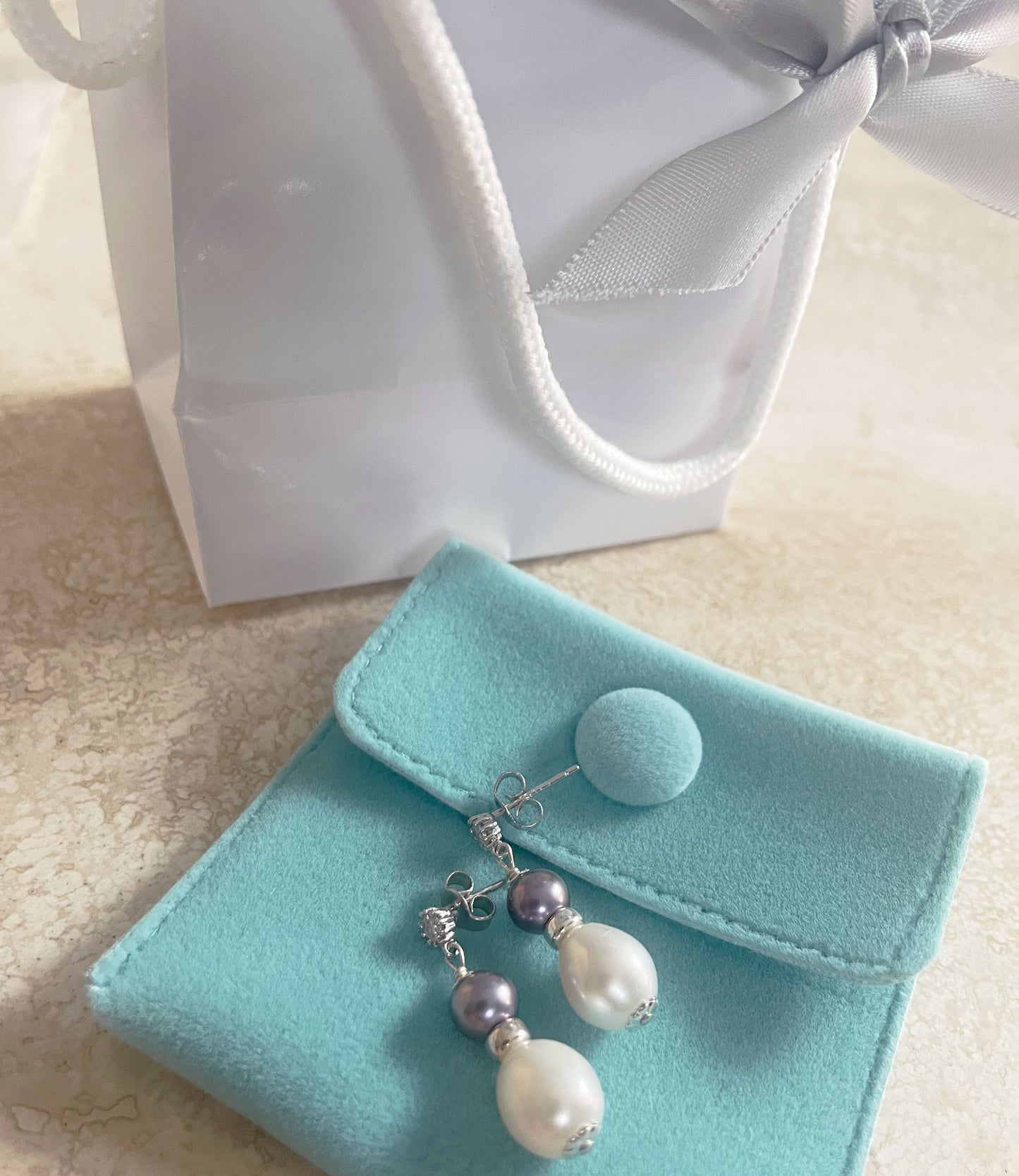 Dangling white and black pearl earrings are perfect gift.  