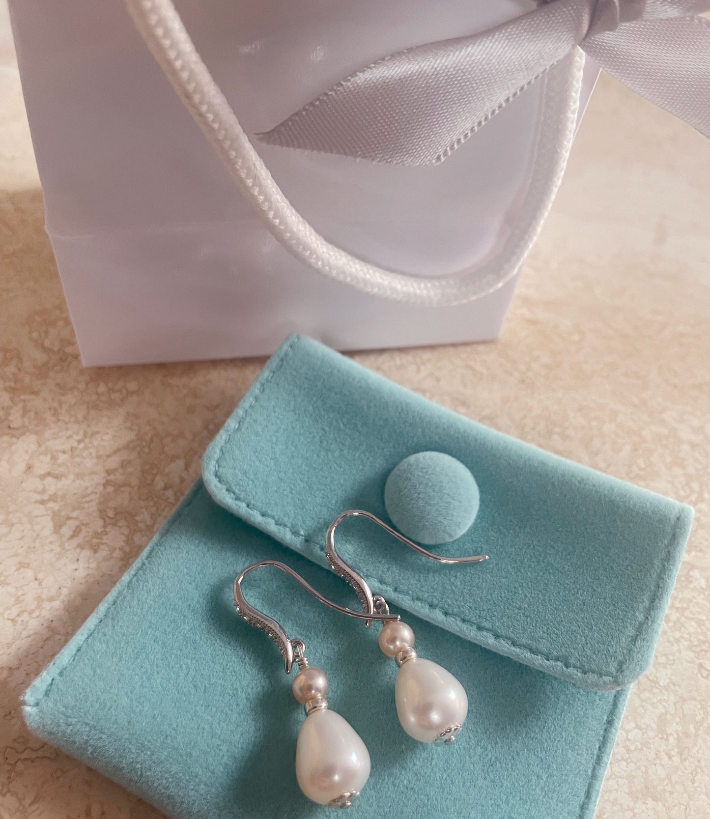 Everyday dangling pearl earrings feature real pearls.  Modern custom white jewelry is a must today.